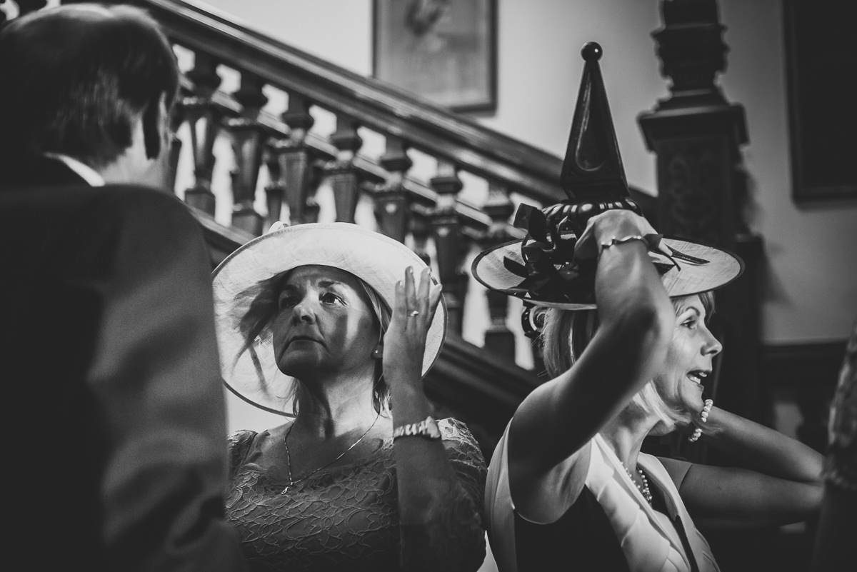 Mothers holding their hats at a wedding receiving line at Arley Hall and Gardens