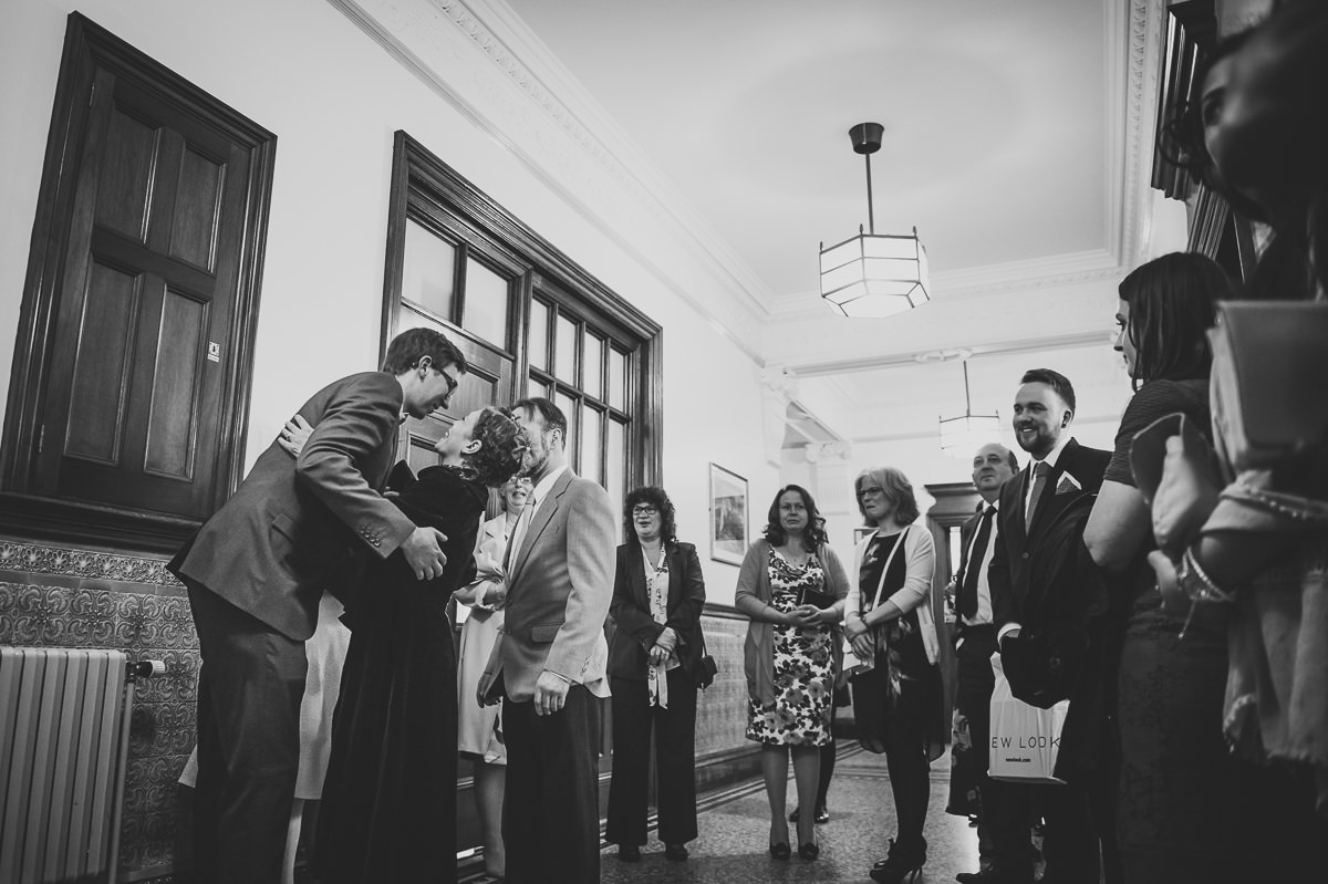 Newly weds greeting and hugging guests at their croydon registry office wedding 