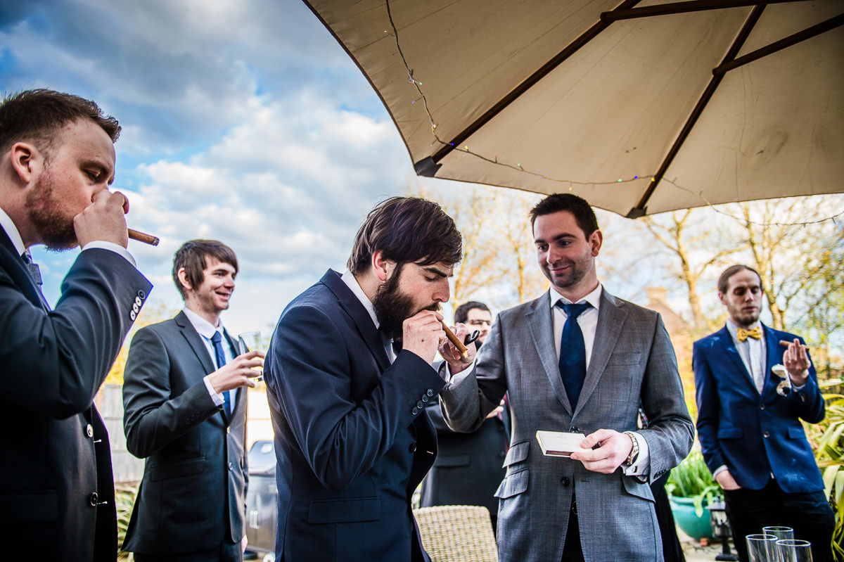 Guests relaxing and smoking cigars at a surrey garden wedding