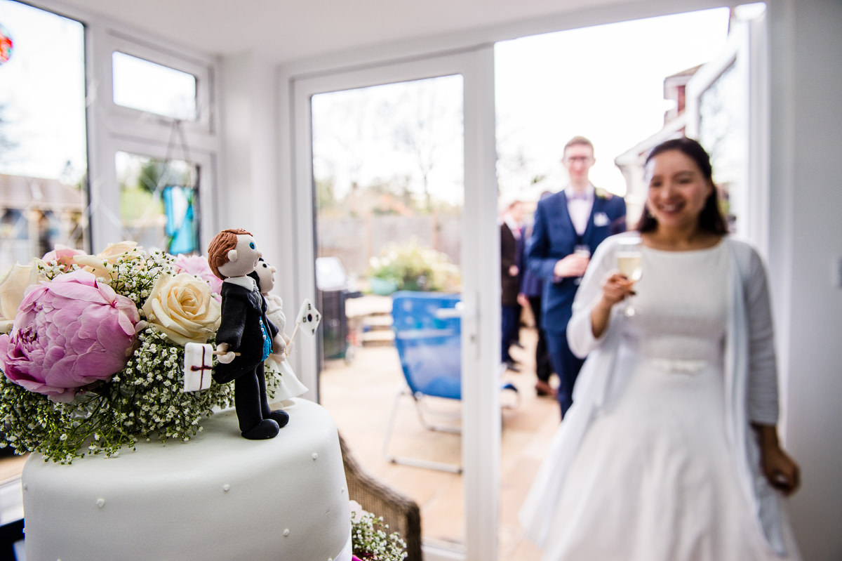 Newly weds coming to cut their wedding cake at their relaxed surrey garden wedding