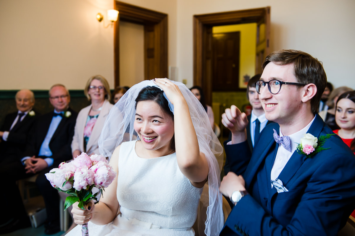 Groom helping his Bride lift her veil 
