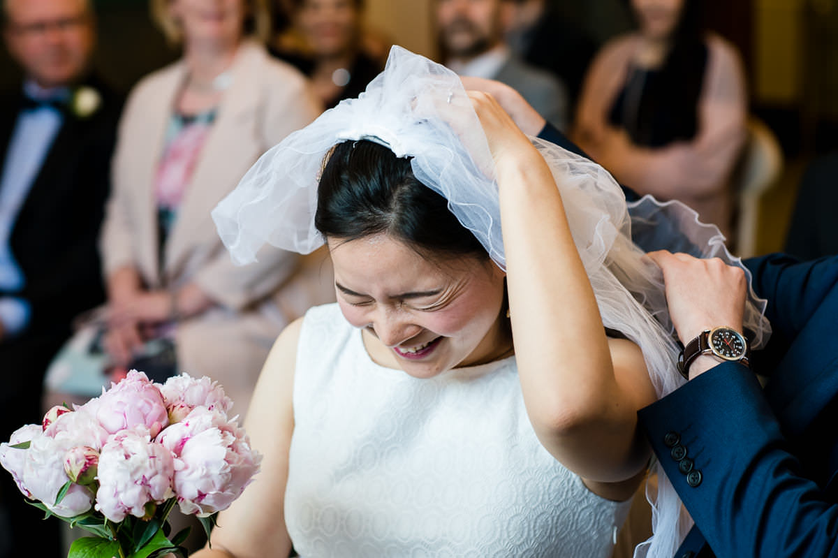 Bride laughing at her veil gets caught at her Croydon Registry office wedding