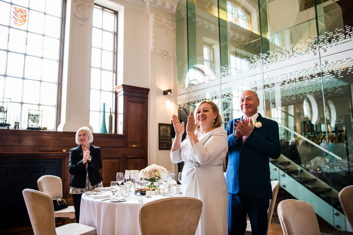brides mother and father clapping as they enter the room