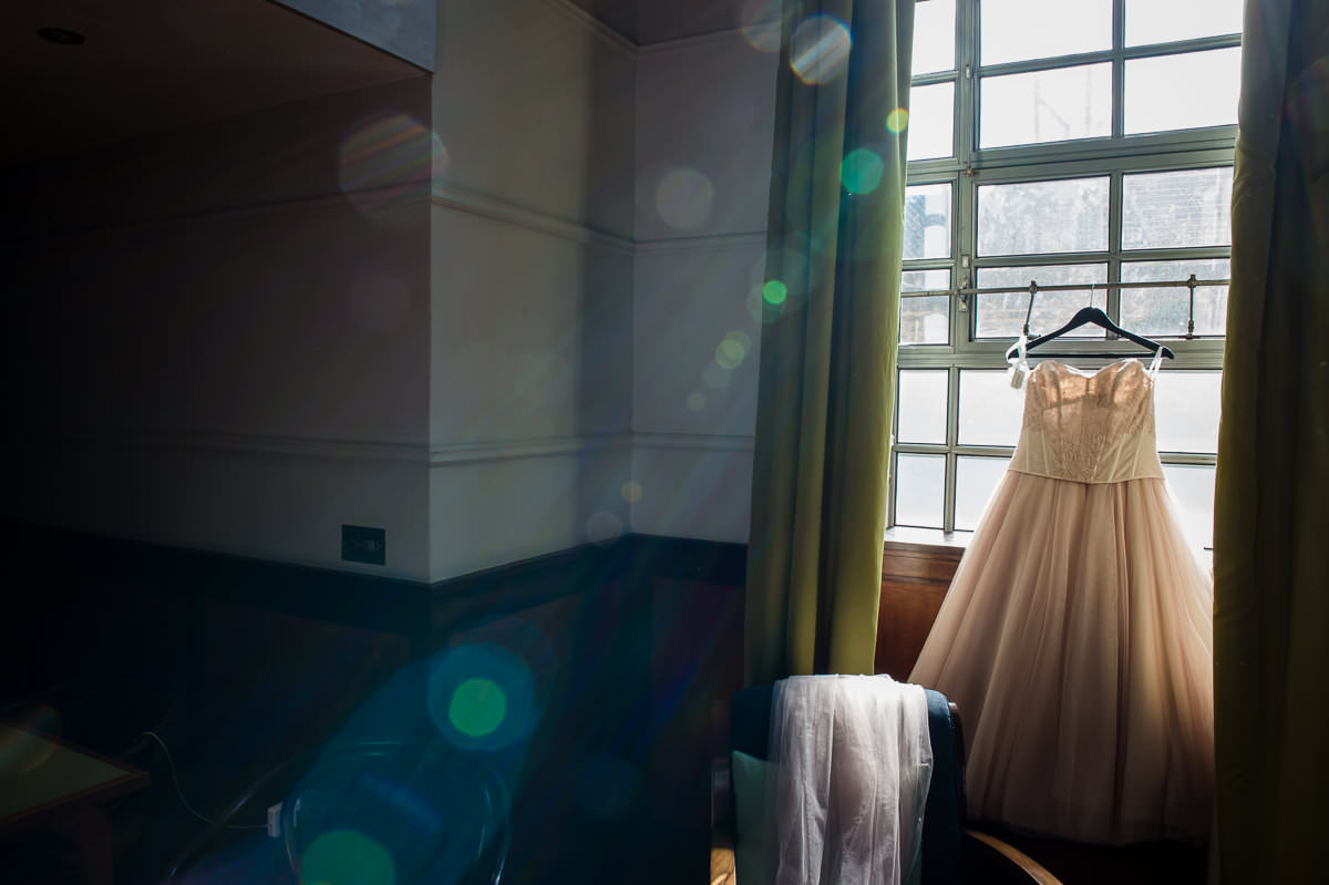 Bethnal Green Town Hall Hotel wedding brides dress hanging in window