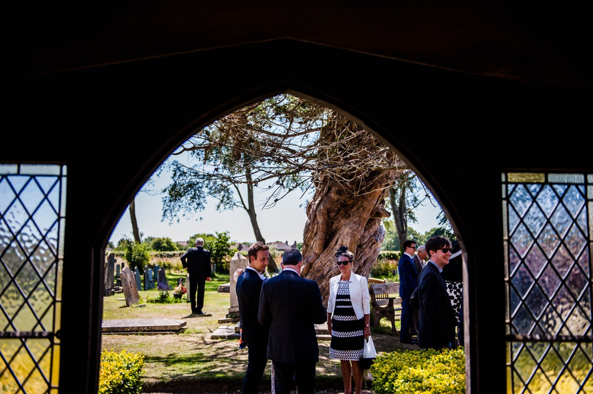guests mingling in the hot sunshine outside church 
