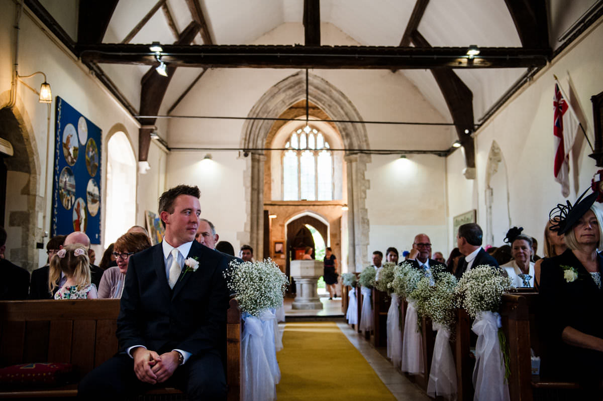 groom waiting at the top of the aisle for his bride to arrive
