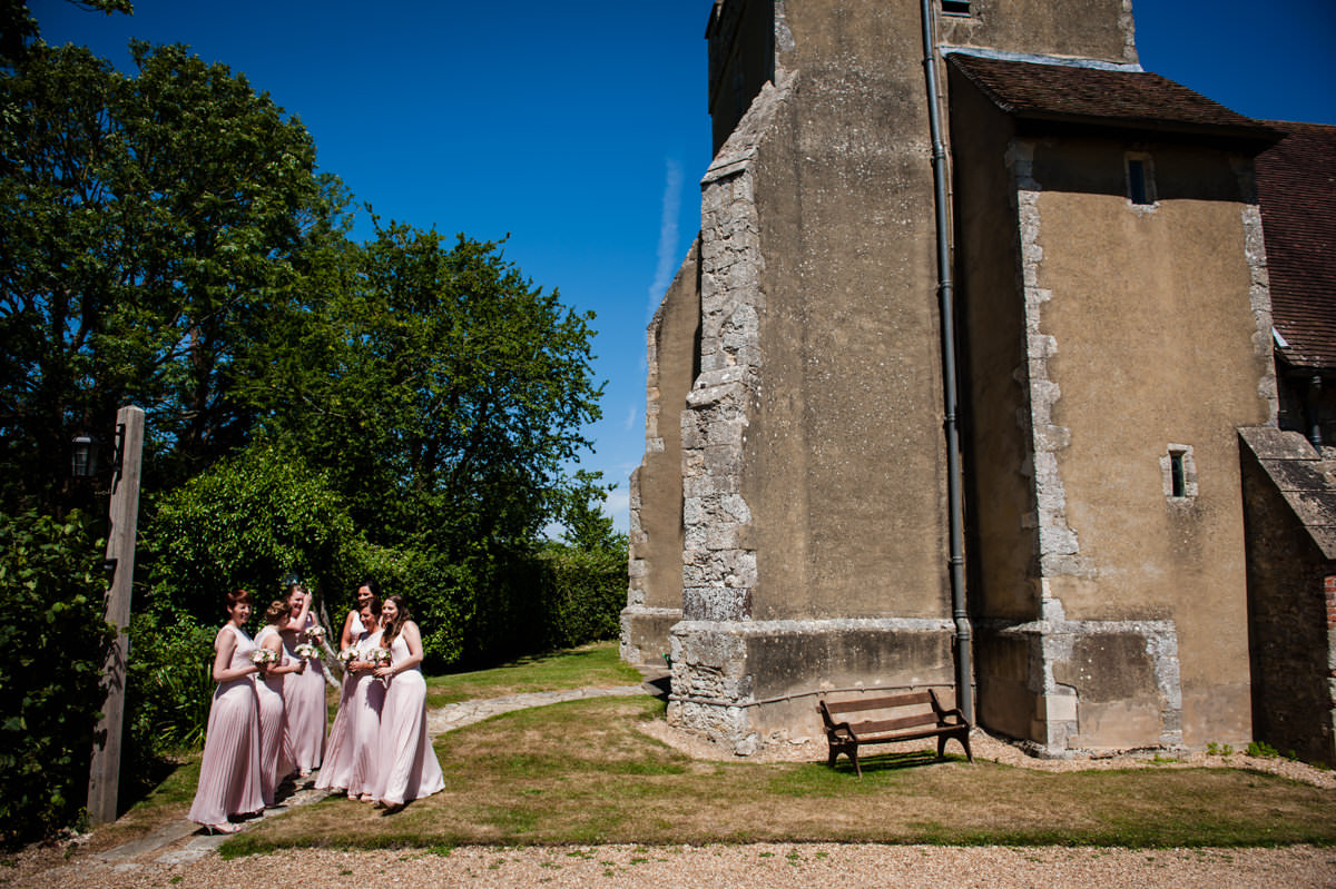 bridesmaids waiting outside of church in pretty pink dresses