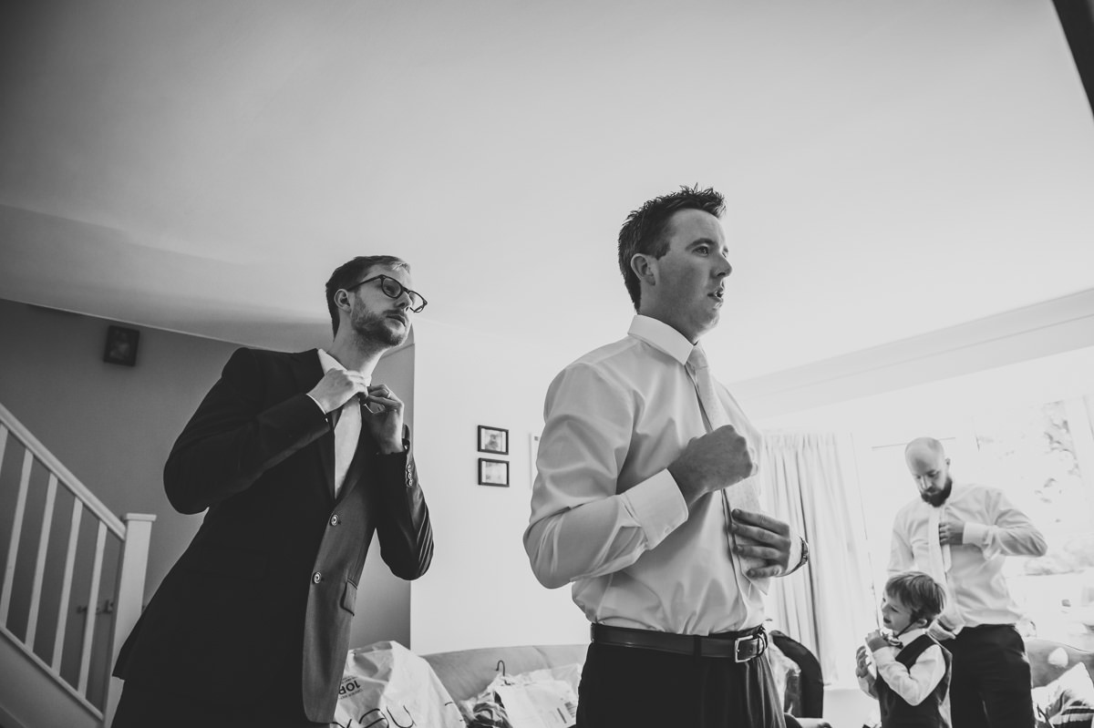 Groom and groomsmen doing up their ties for wedding