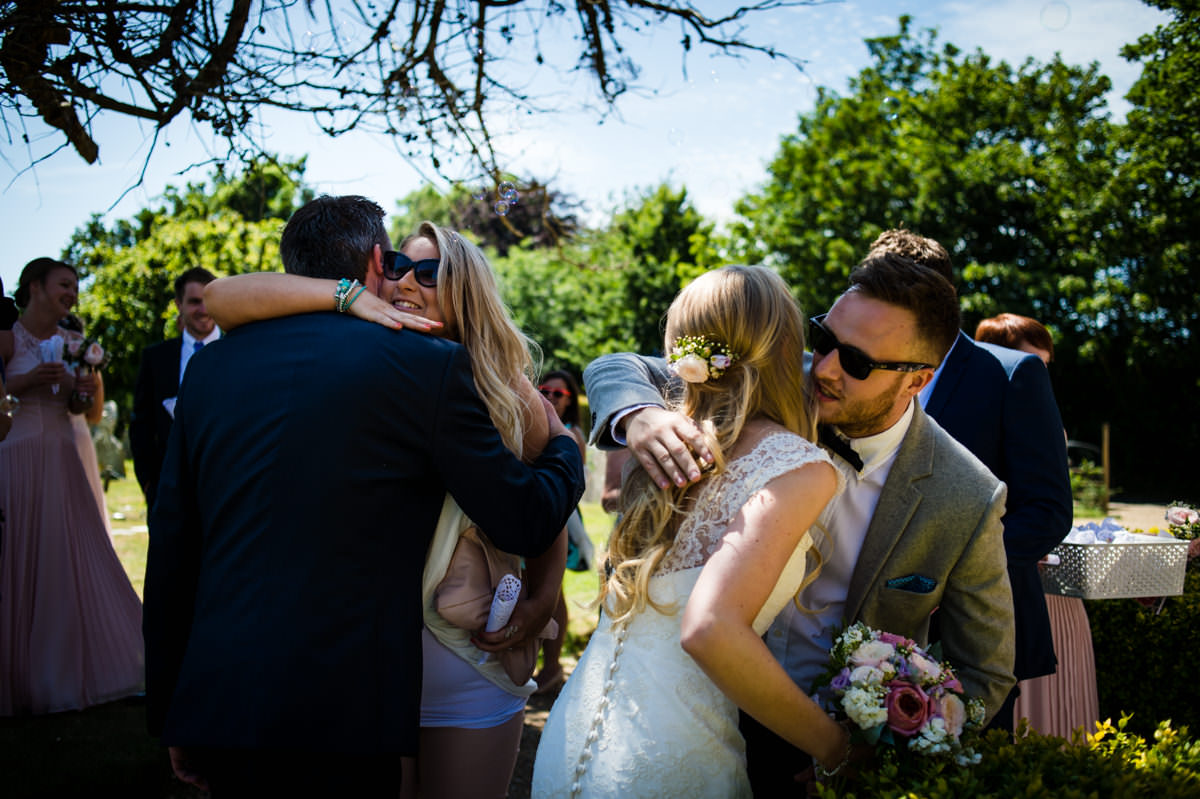 Bride and Groom hugging guests at their Sussex wedding