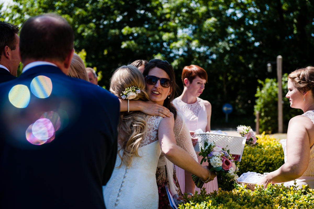 Bride hugging guests at her wedding