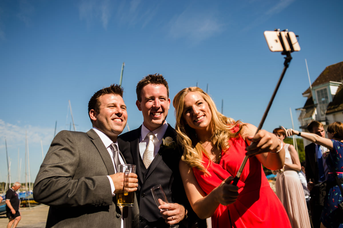 Groom and guests taking selfies at west sussex wedding