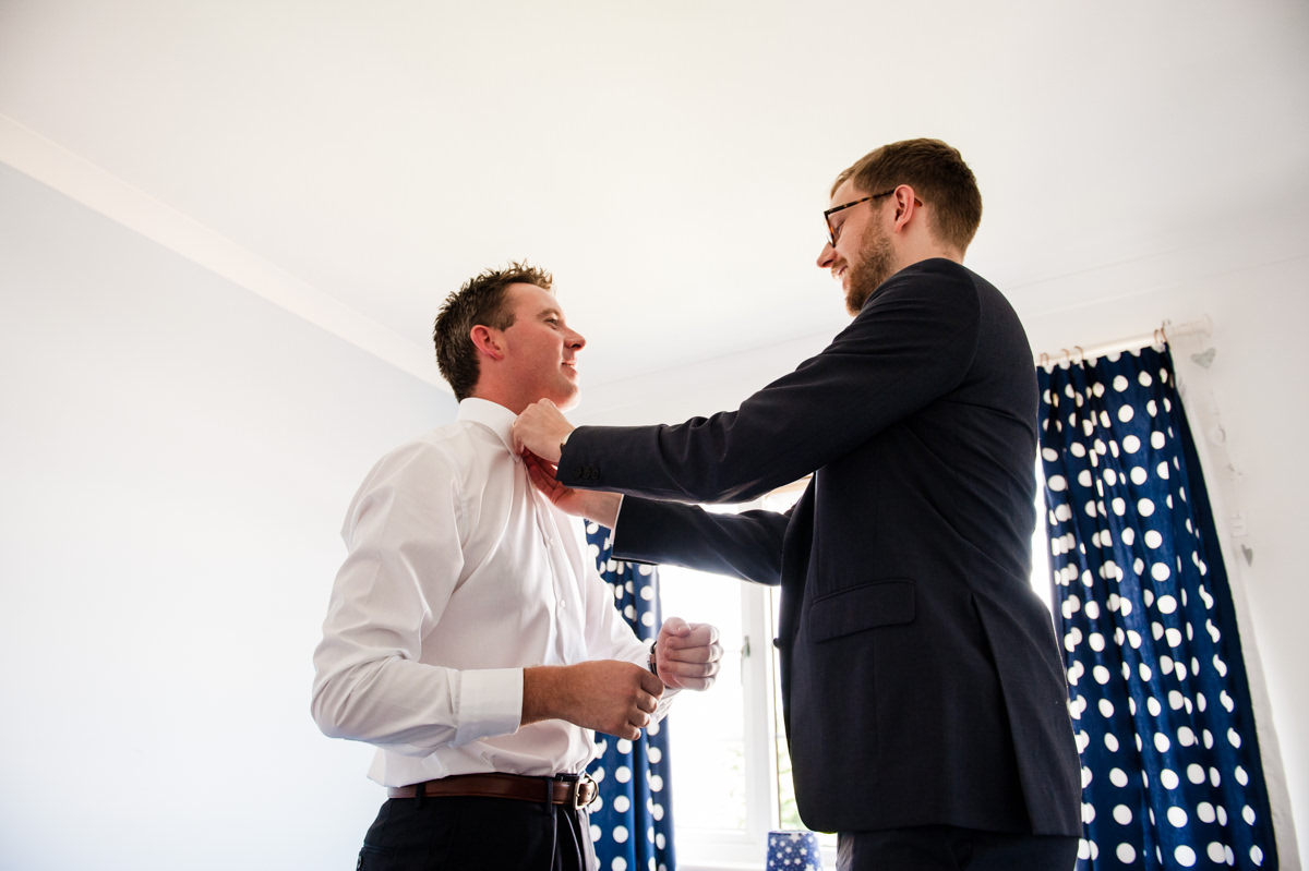brother helping from with wedding tie