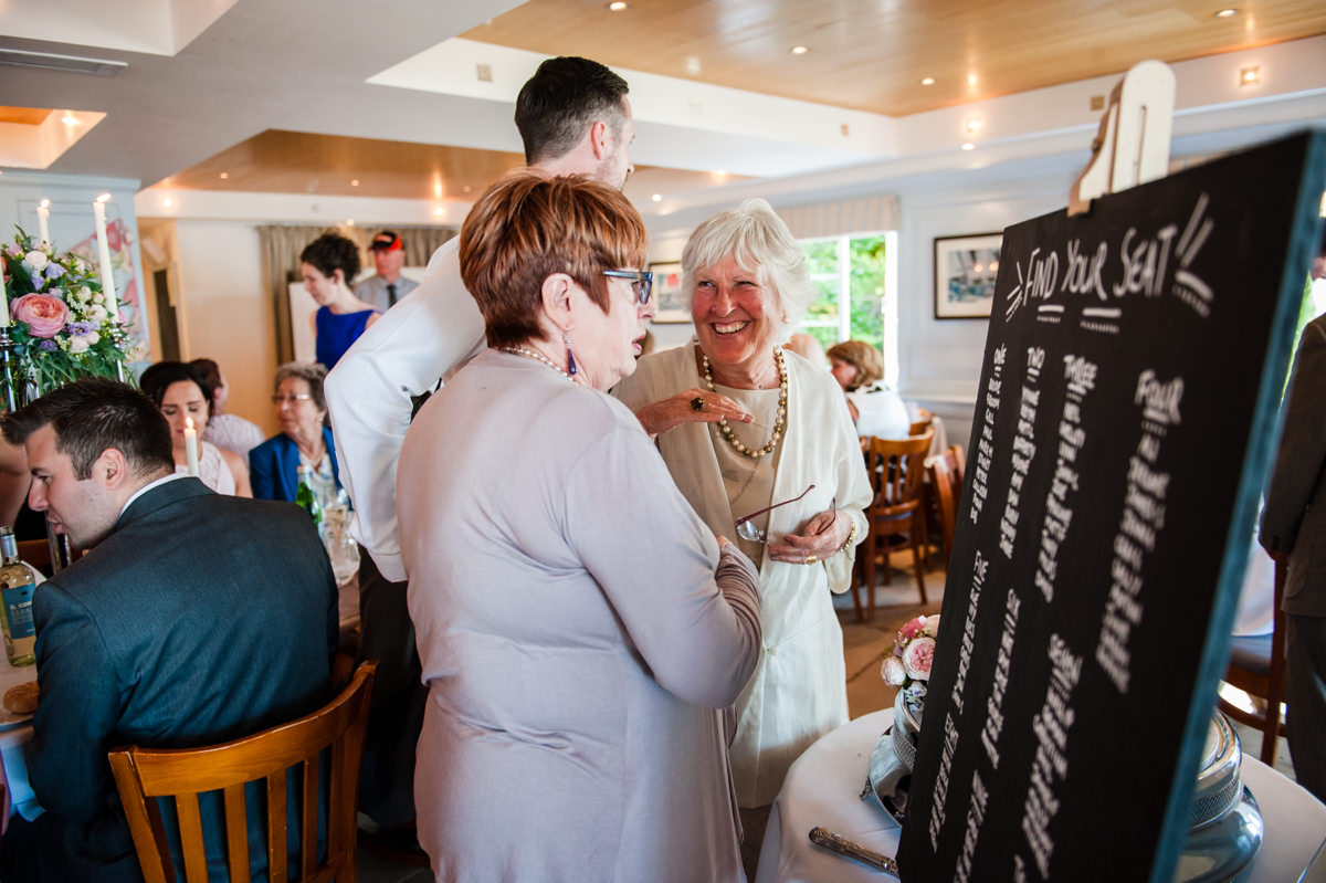 Guests looking at seating plan at Itchenor Sailing Club wedding