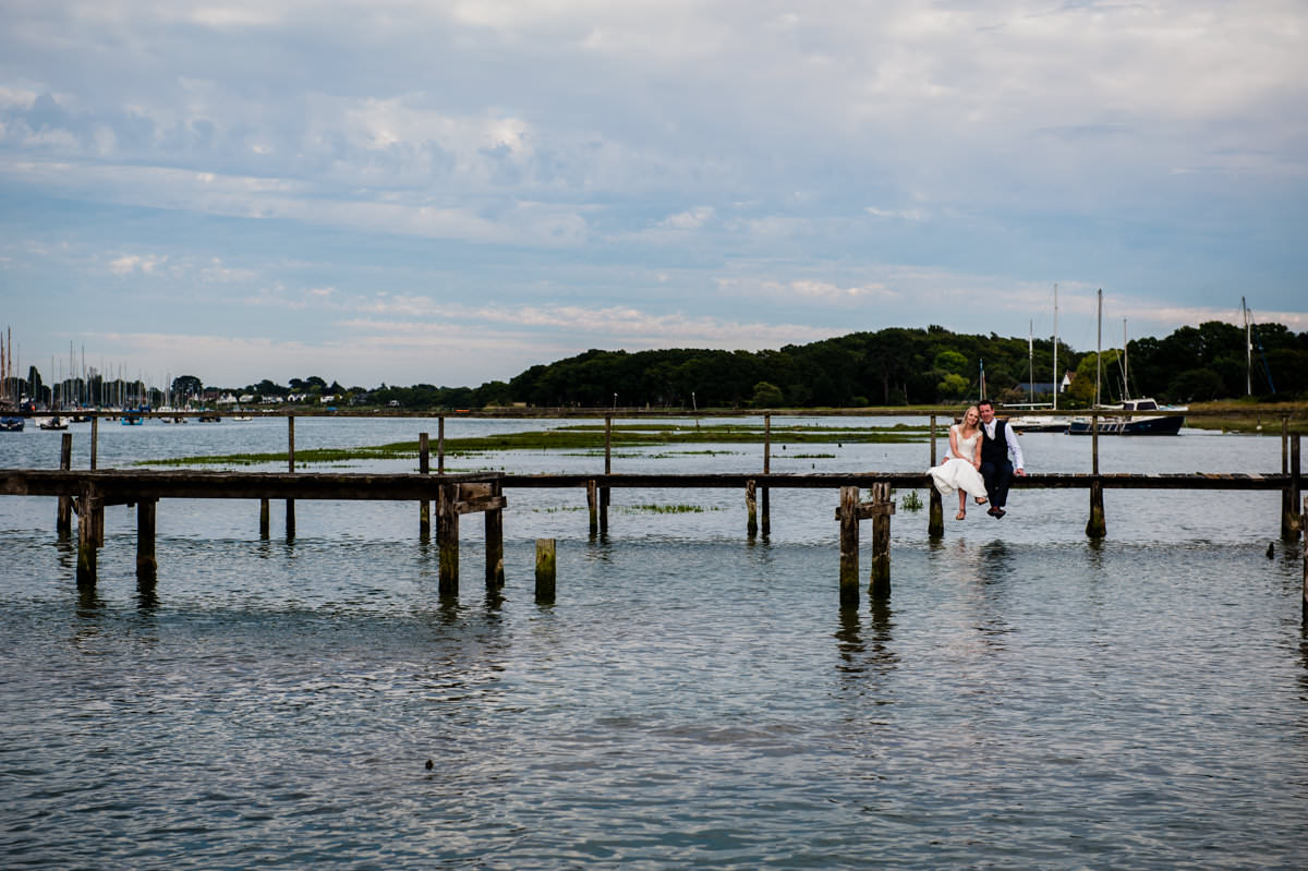 Gorgeous photo of bride and groom on jetty at Itchenor Sailing Club wedding
