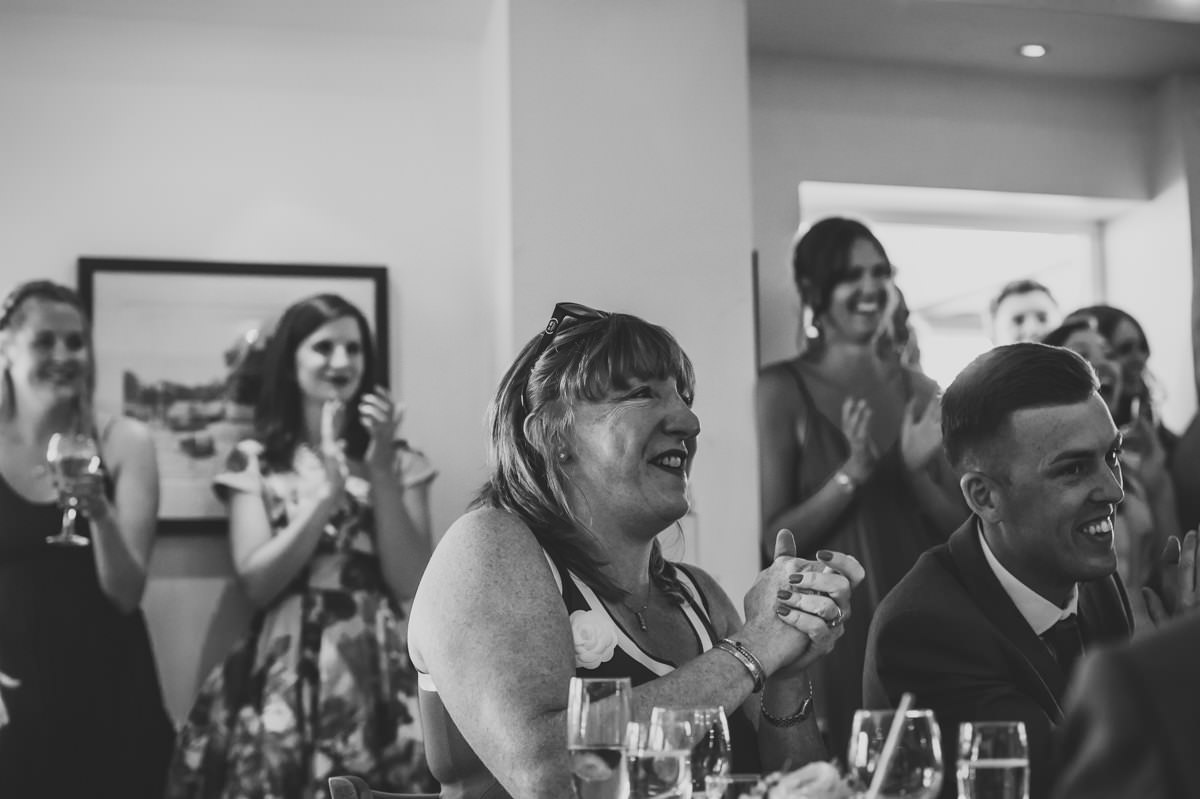Wedding guests applauding to speeches at Itchenor Sailing Club