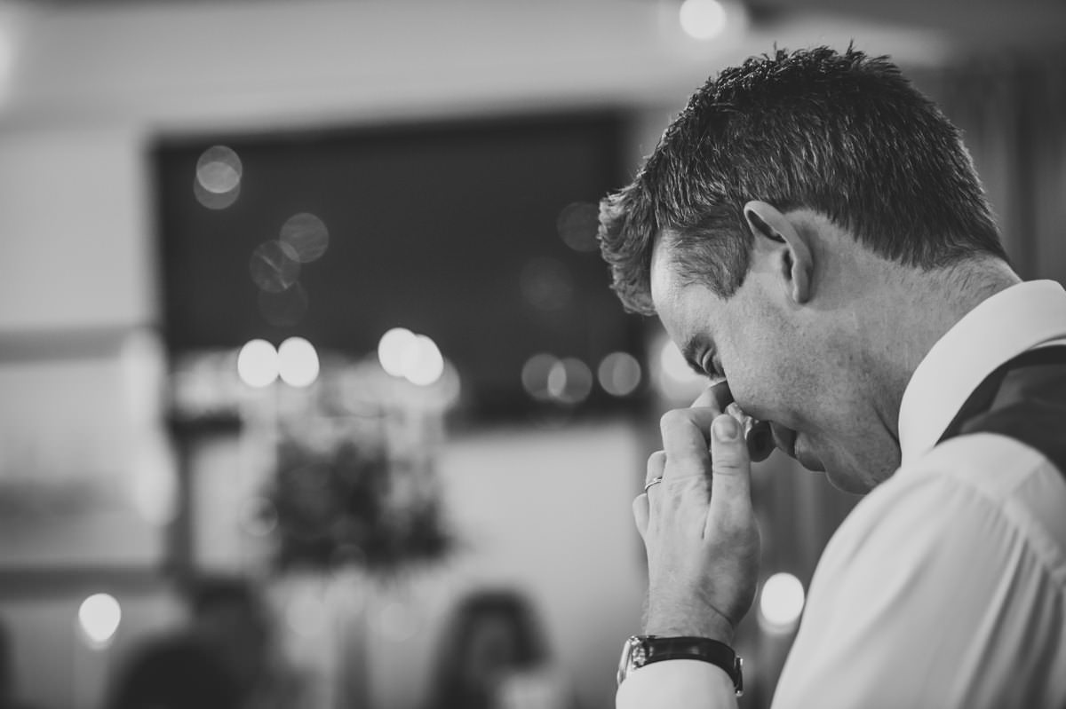 groom making is wedding speech wiping away a tear at Itchenor Sailing Club