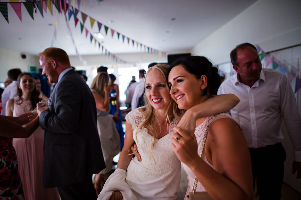 Bride looking on as guests are dancing at her wedding