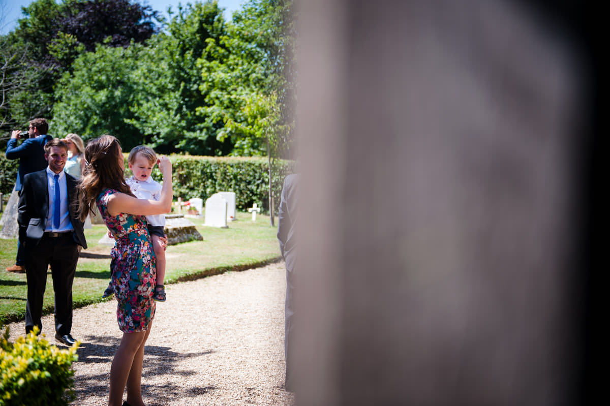 mother brushing back her son's hair before a wedding 