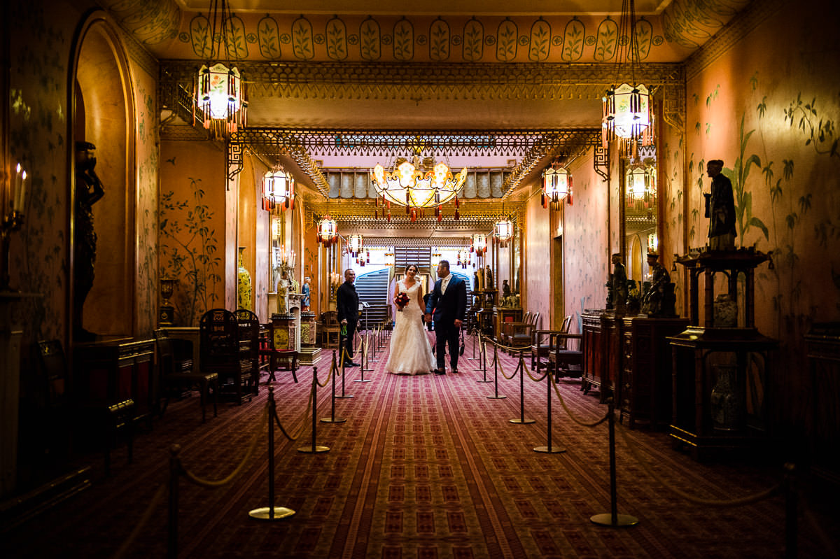 Newlyweds walking hand in hand along the corridors of the Royal Pavilion in Brighton