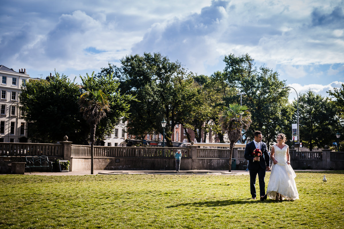 Newly weds walking across the kings lawn at the Royal Pavilion