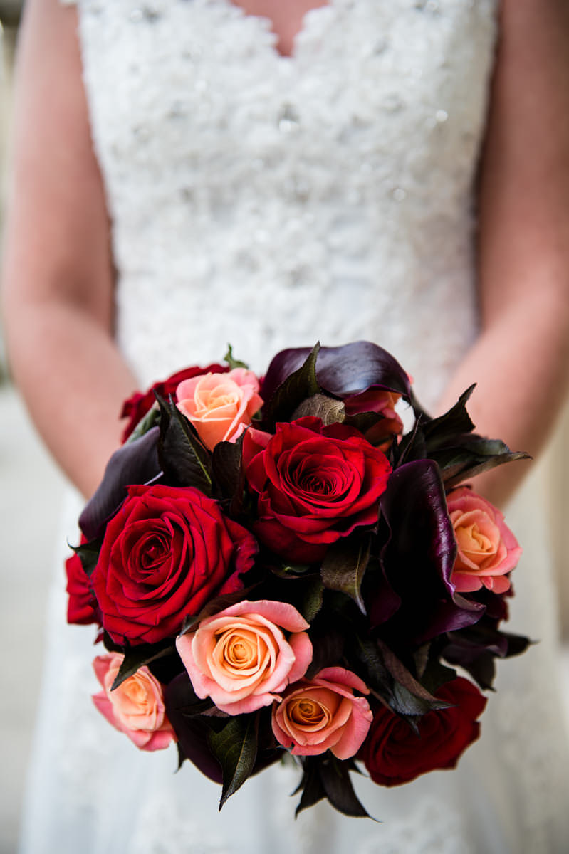 Bride's autumnal bouquet of red roses and cala lillies