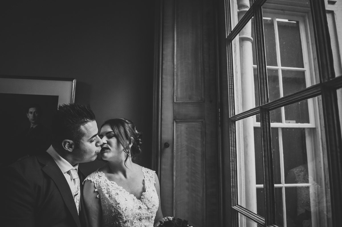 Bride and Groom kissing at the door of the pavilion