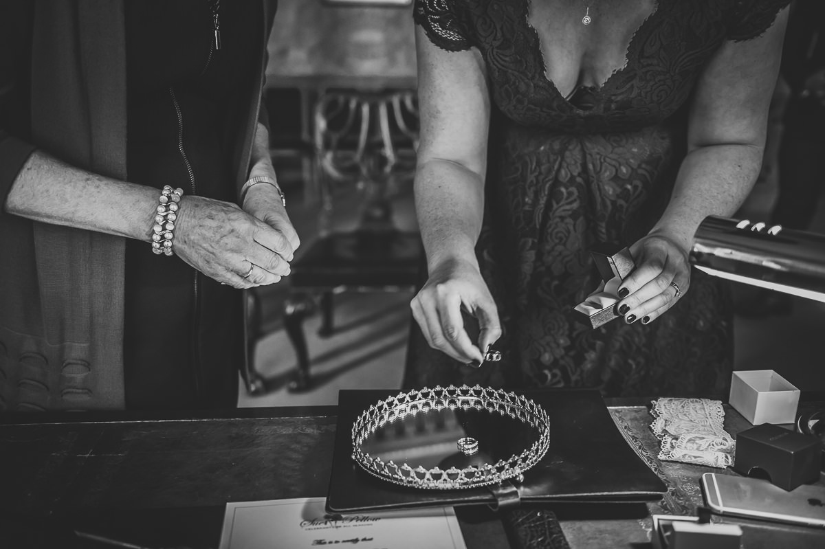 Brides mum and sister putting wedding rings on tray