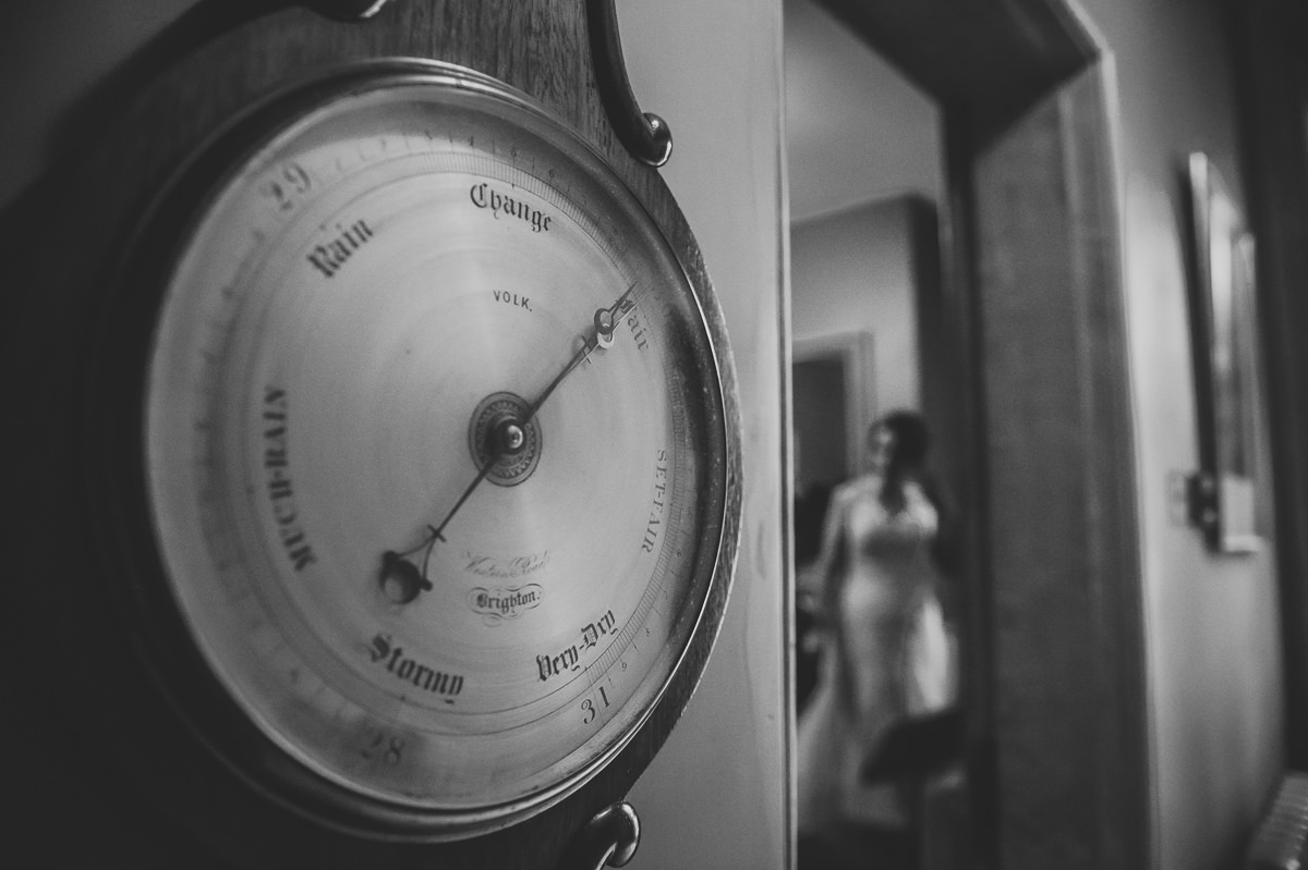 Weather barometer says fair, with bride in white dress in the background at the royal pavilion