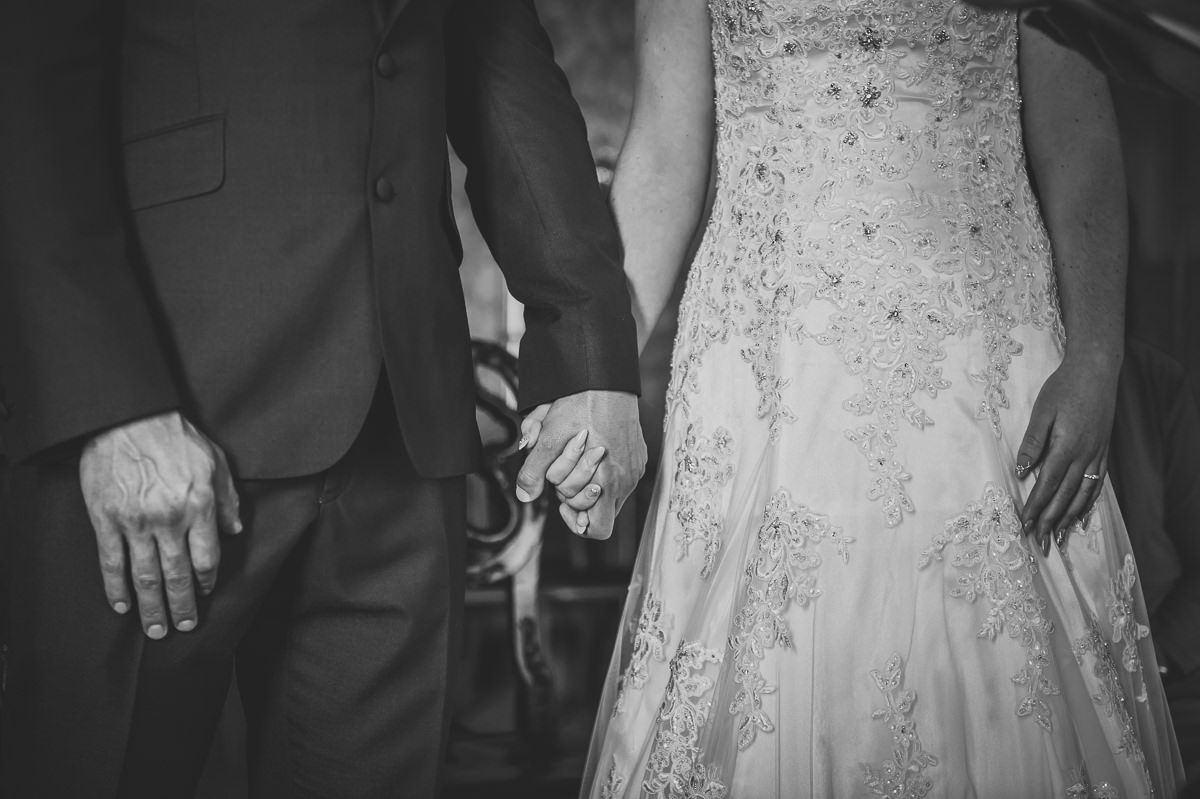 newly married couple holding hands after their wedding ceremony in the red drawing room