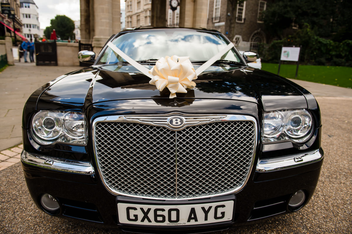Black bentley arrives with bride and groom ready for their brighton pavilion wedding ceremony
