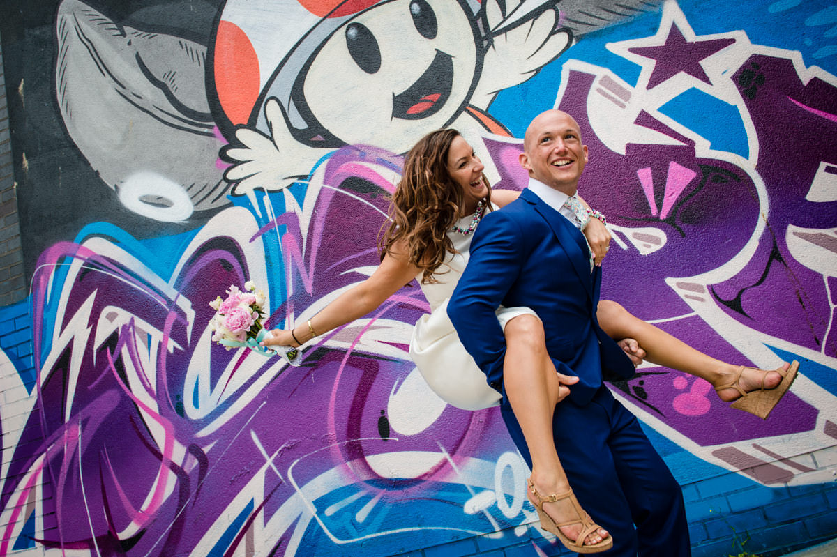 Bride and Groom playing piggy back down the lanes in Brighton