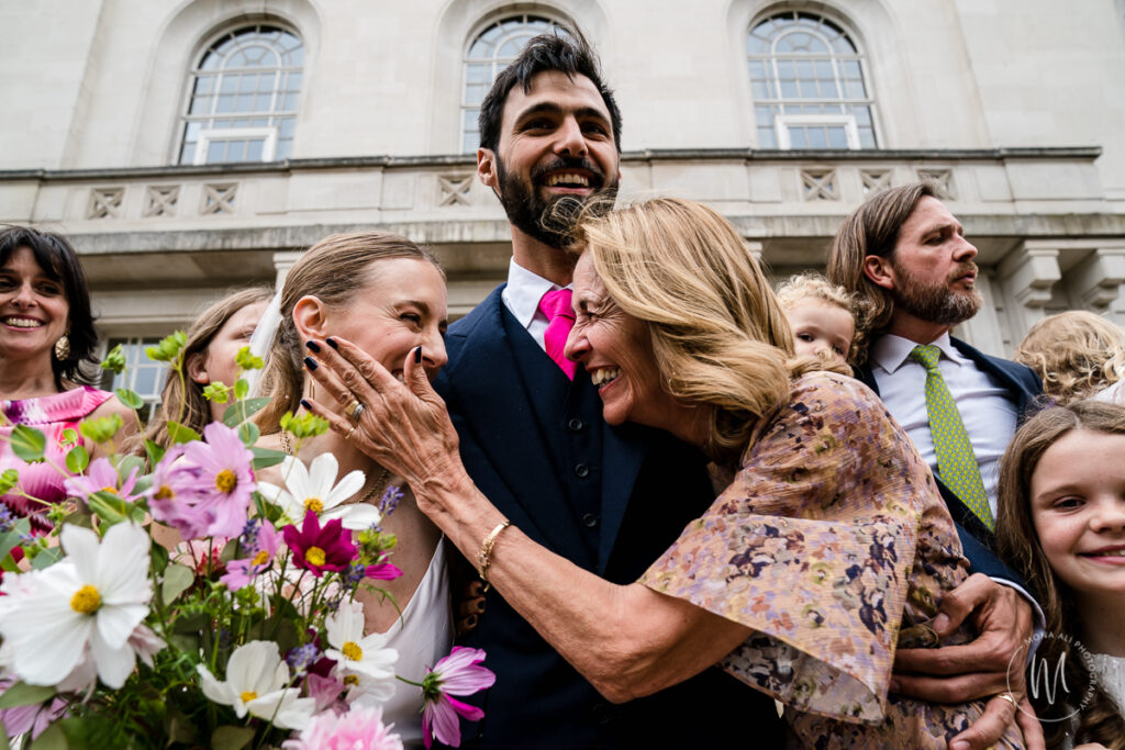 groom's mother affectionately touching the bride's face after the wedding
