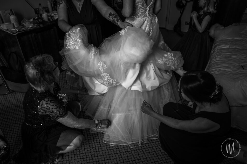 bride being helped into her dress