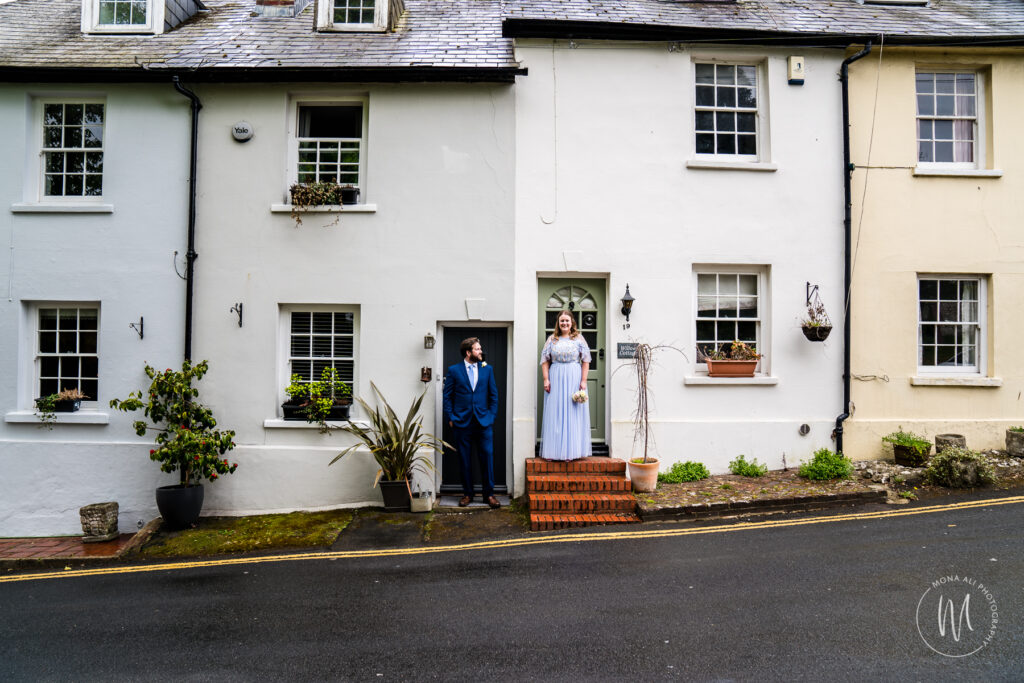 bride and groom standing outside cottages in Patcham Village after their church wedding