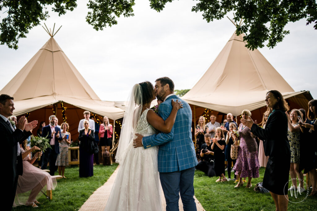 Bride and groom kissing at their festival style wedding in East Sussex