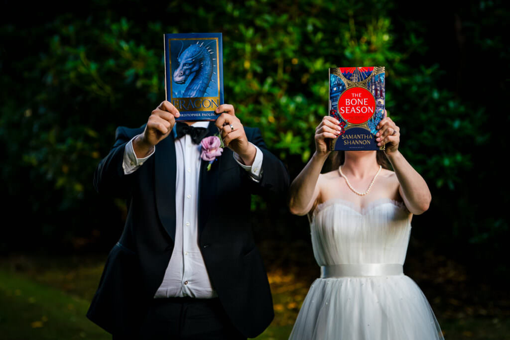 Shy bride and groom with their favourite books at their Gorse Hill hotel wedding