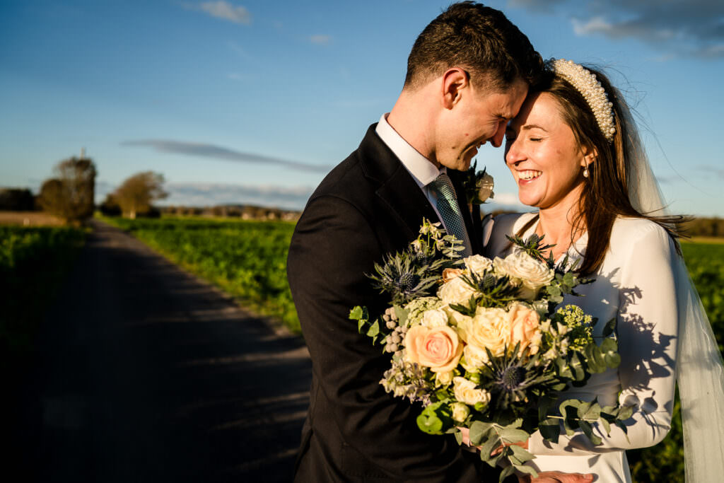 bride and groom snuggling up in their wedding photos in Chidham Barn