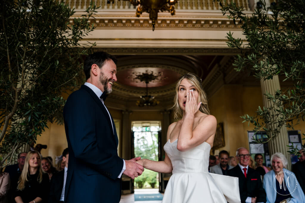 Beautiful bride wiping away a tear at her Hampton Court House wedding ceremony