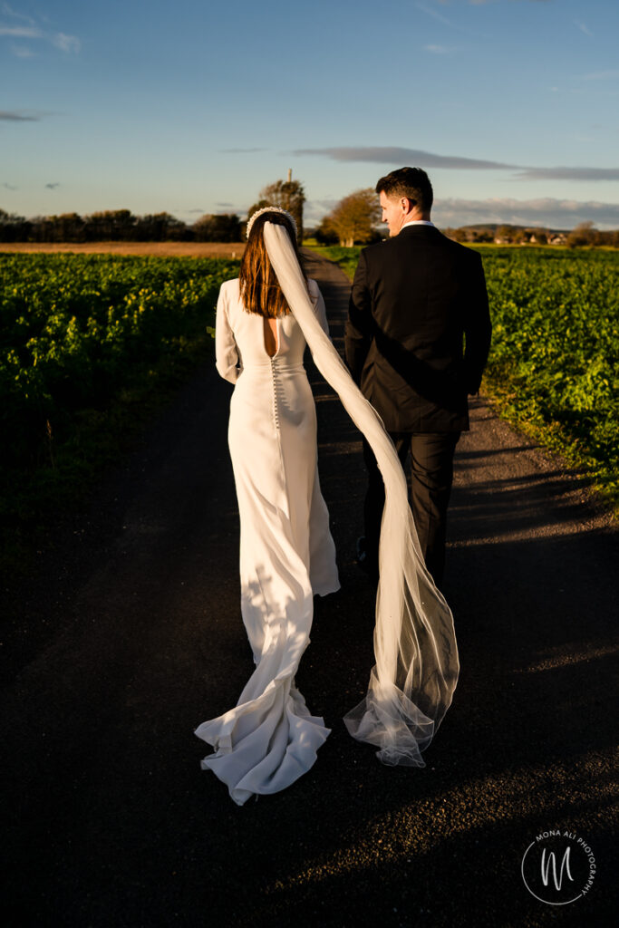 Bride and Groom walking towards Chidham Barn on their wedding day